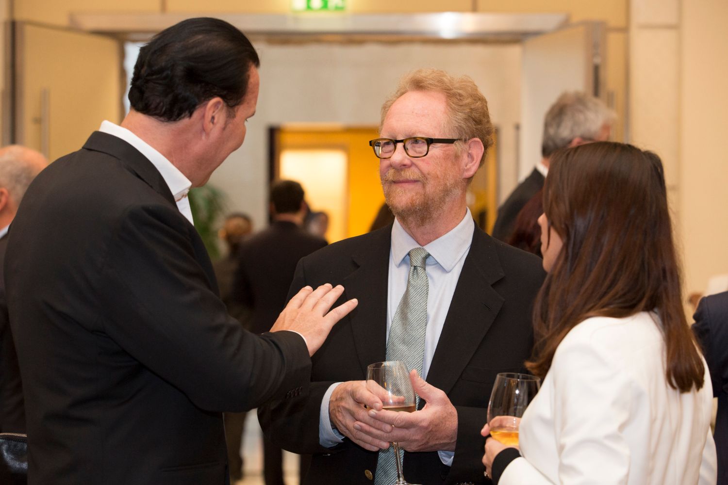 Three men and a woman at a social event.